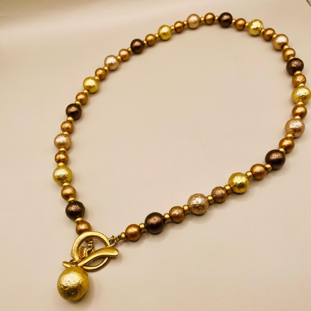 Champagne color pearls and brass color beads necklace with a toggle closure.